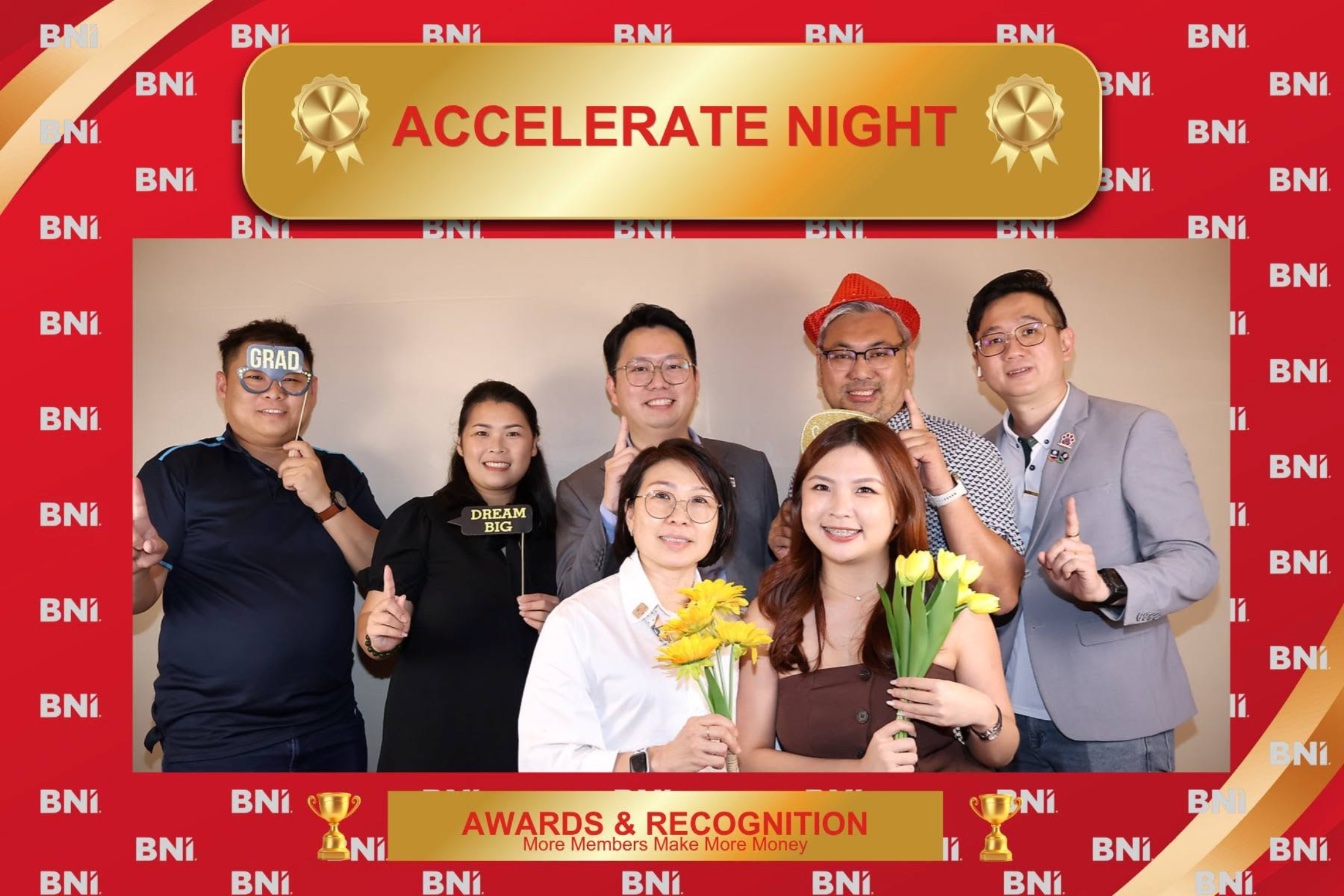 A group of association members posing together inside a branded event frame